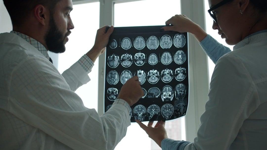 Clinician reviewing medical scans on a screen in a hospital ward