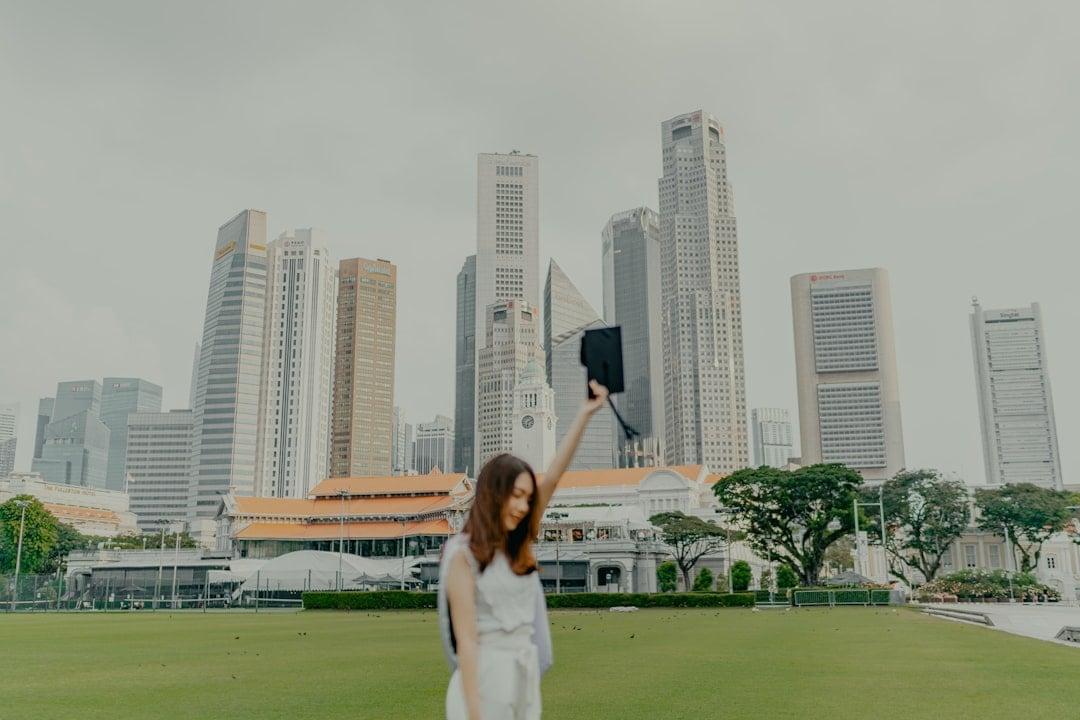 a woman in a white dress holding up a black object in front of a city | Photo by Albert Vincent Wu on Unsplash