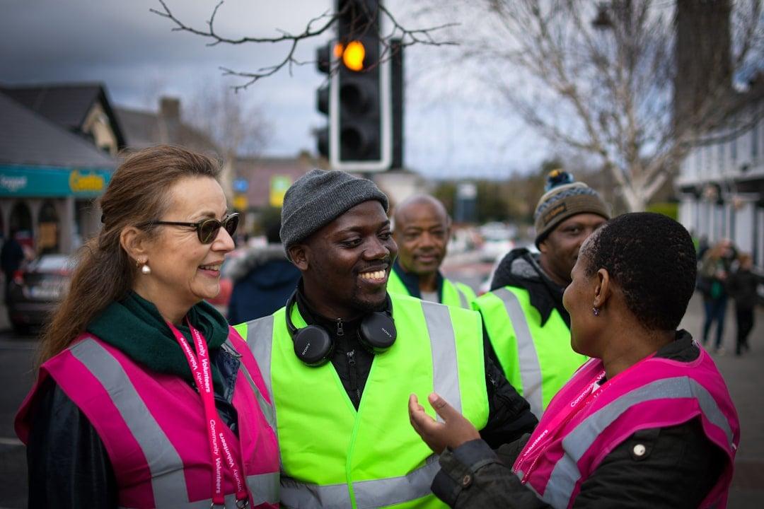 Smiling community volunteer wearing a high-visibility vest at an outreach event